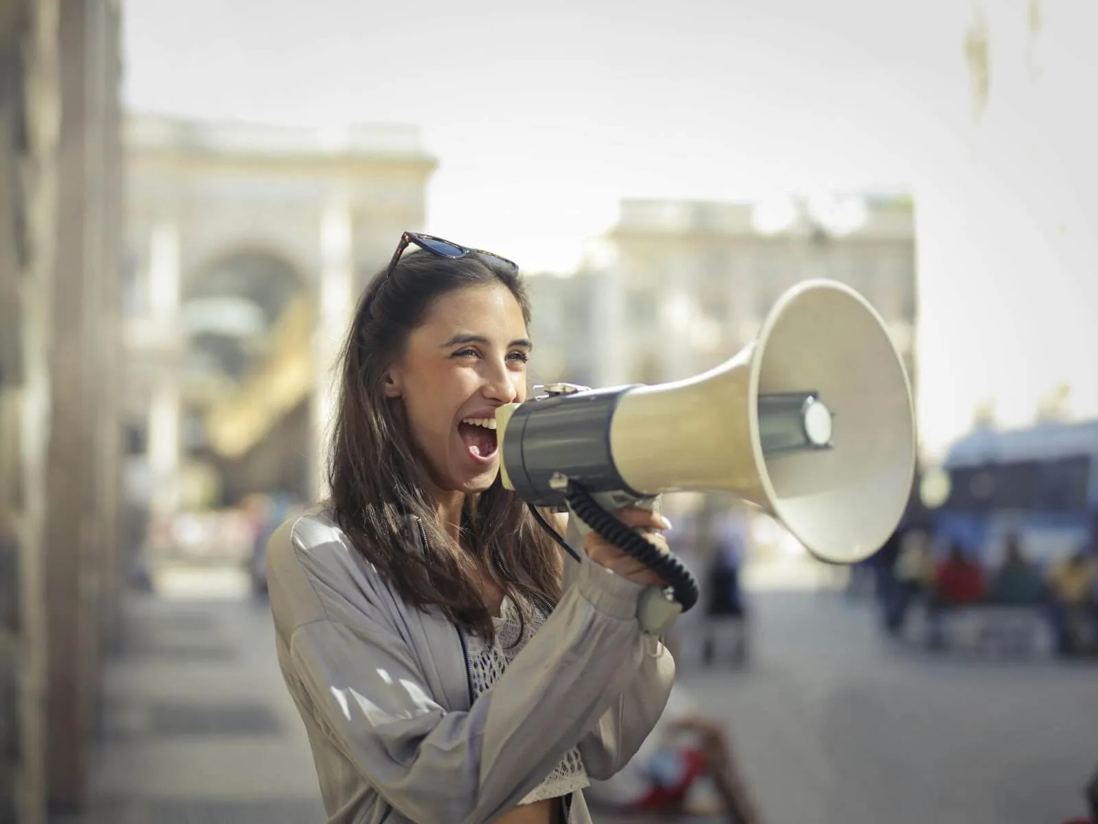 A lady using a megaphone talking to people.