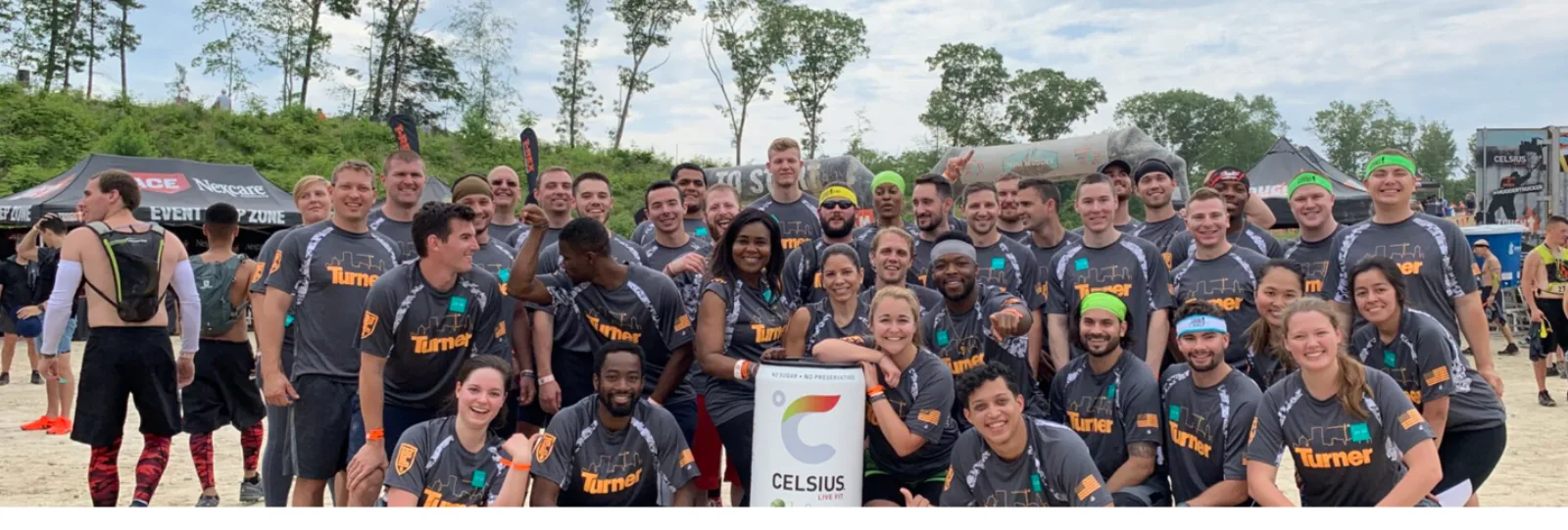 A group of Tough Mudder participants posing with CELSIUS energy drinks