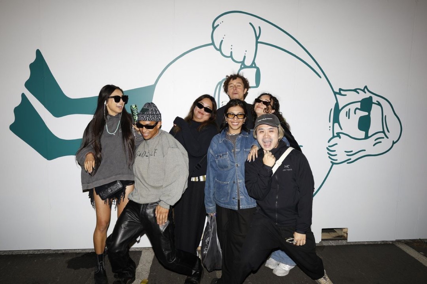 Group of friends posing together at a branded social media activation wall
