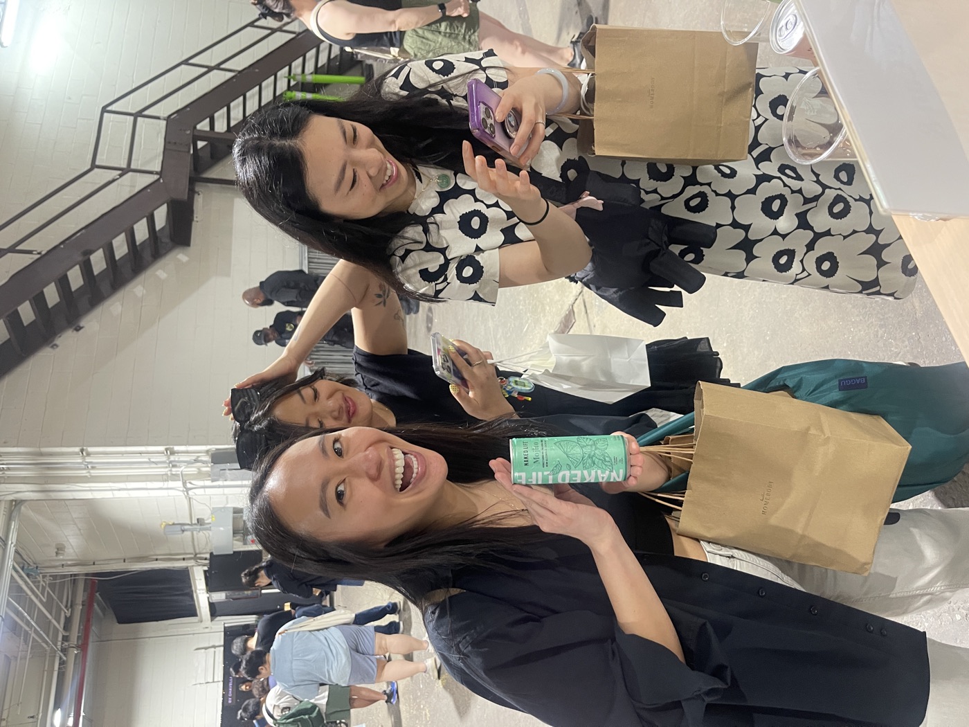 Friends sharing photos on their phones at a branded sampling event, an example of user-generated content in action