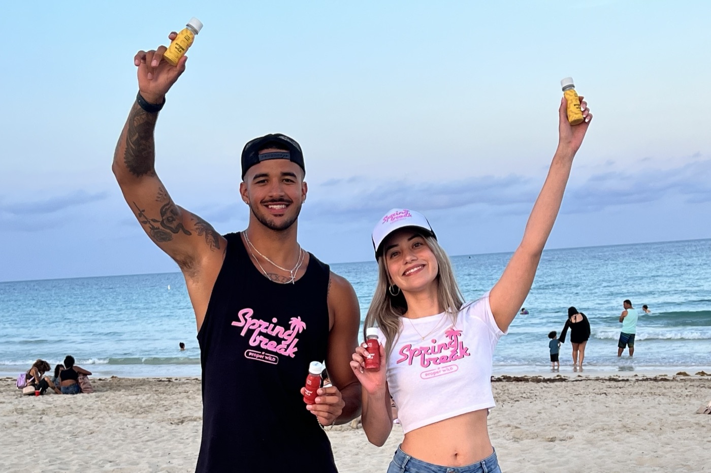 Brand ambassadors sampling Proper Wild energy shots on the beach during a CPG street team marketing activation